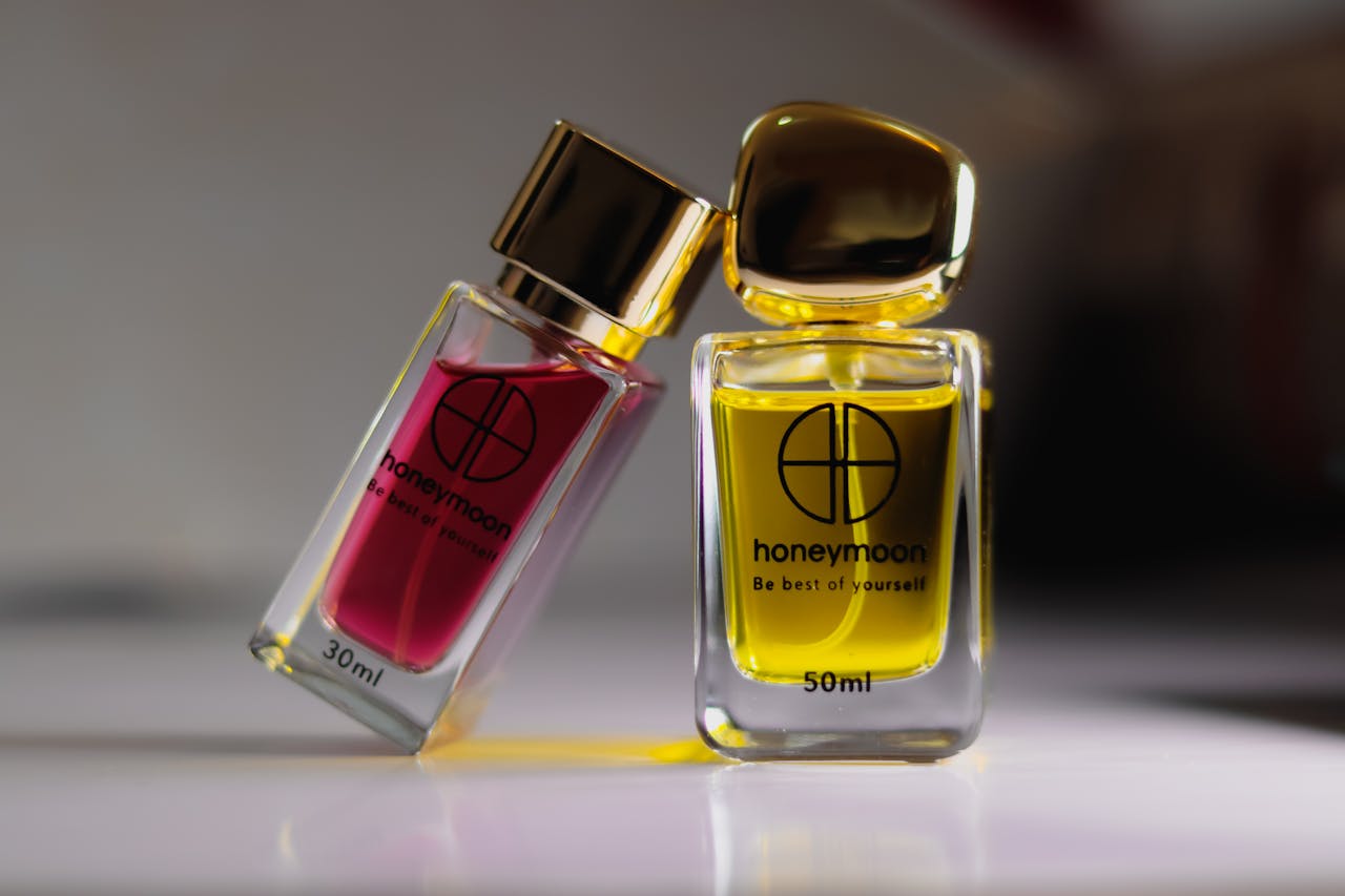 Close-up of luxury perfume bottles with gold caps on a white surface, ideal for product photography.
